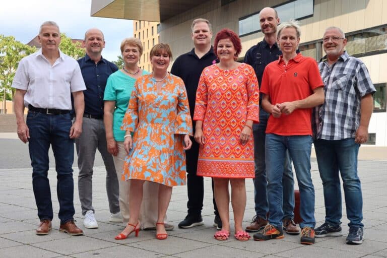 Gruppenbild der Freien Wähler Ostfildern: neun Frauen und Männer stehen nebeneinander auf einem Platz vor einem modernen Gebäude.