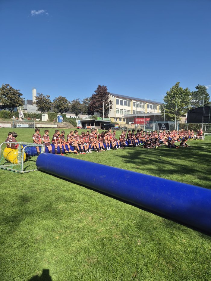 Teilnehmende des Rabauken-Camps sitzen auf dem Sportplatz des TV Kemnat