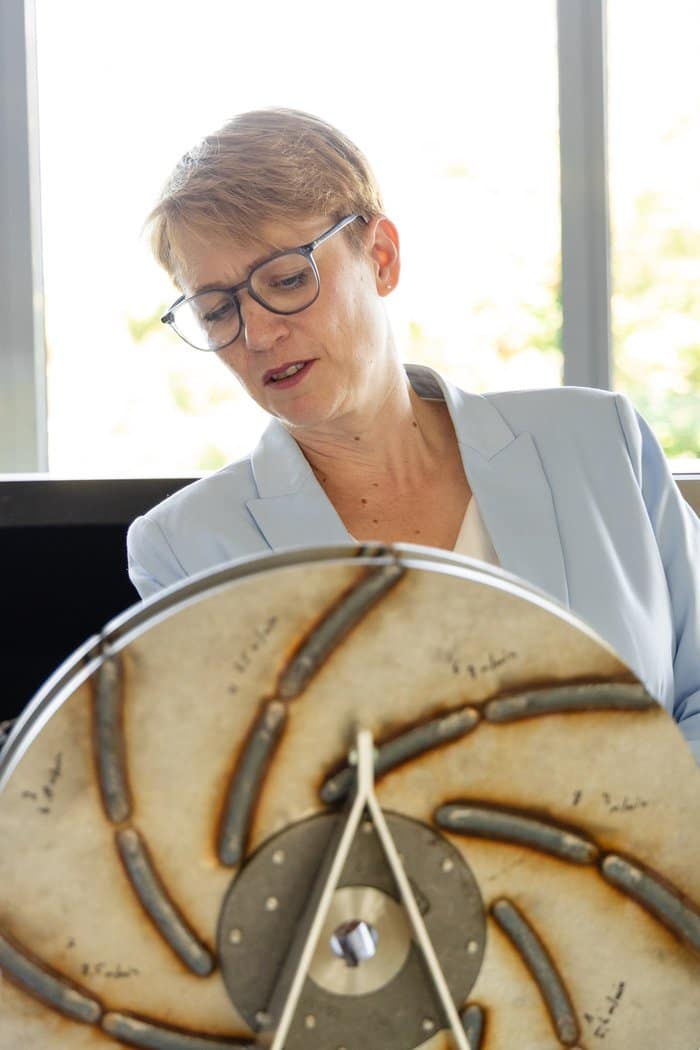 Andrea Lindlohr MdL betrachtet ein Laufrad aus der Lufttechnik von Elektror