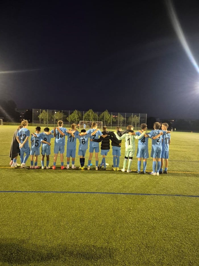 Die C-Jugend des TV Kemnat steht Arm in Arm am Spielfeldrand unter Flutlicht beim Elfmeterschießen