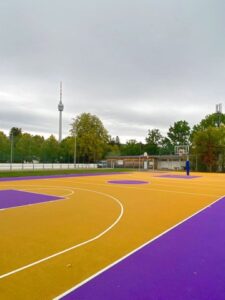 Neues Streetballfeld in Violett und Gelb auf der Waldau, im Hintergrund der Fernsehturm